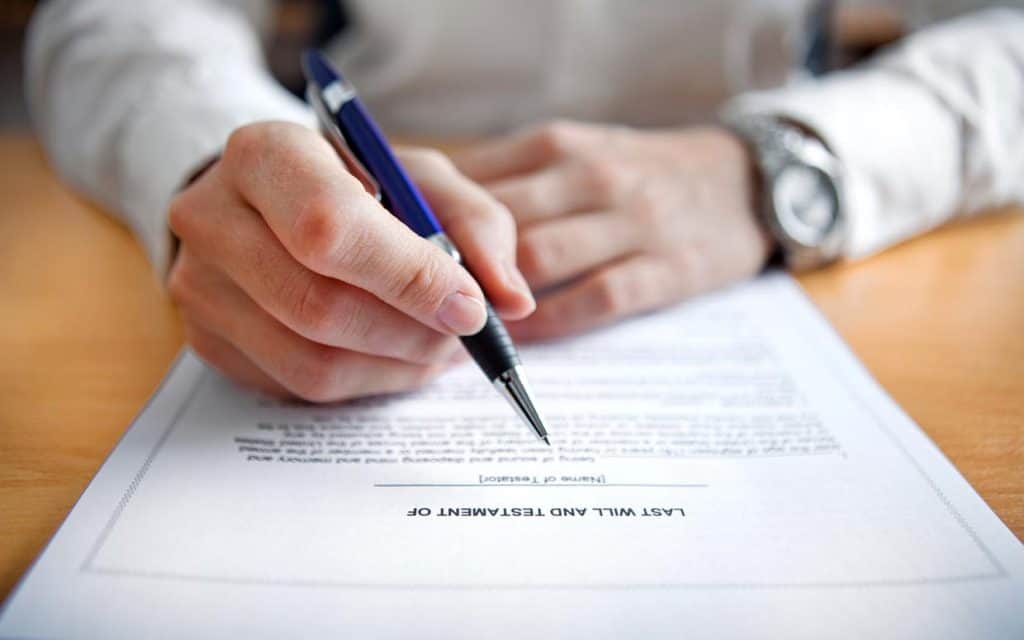 A person signing a legal document with a pen.
