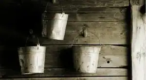 Buckets hanging on a wooden wall.