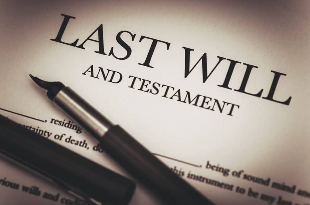 Estate planning legal document with a pen on "Last Will and Testament" form.
