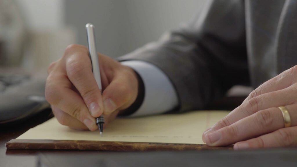 Business professional signing legal documents for personal injury case.