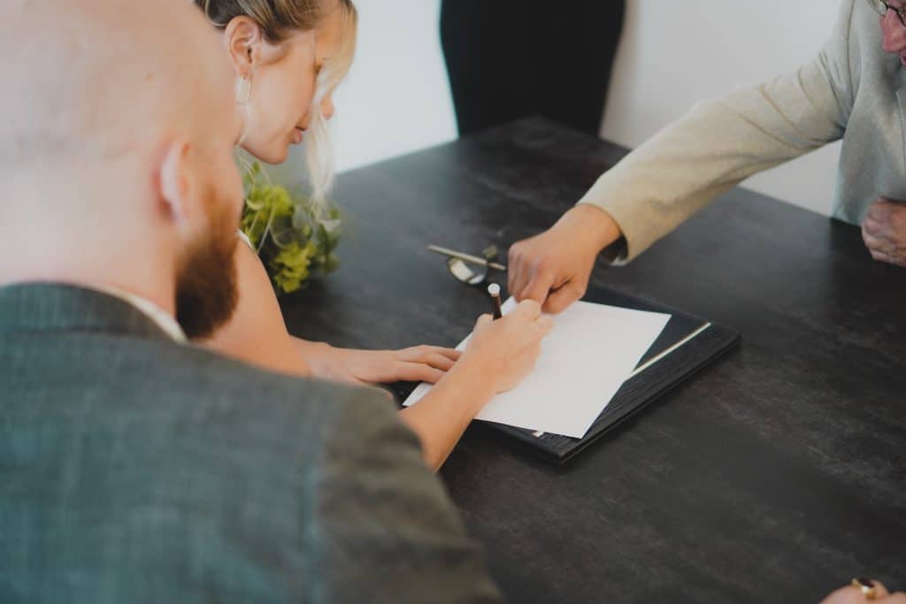 A lawyer and clients discussing legal matters, reviewing paperwork, and providing legal advice in a professional setting.