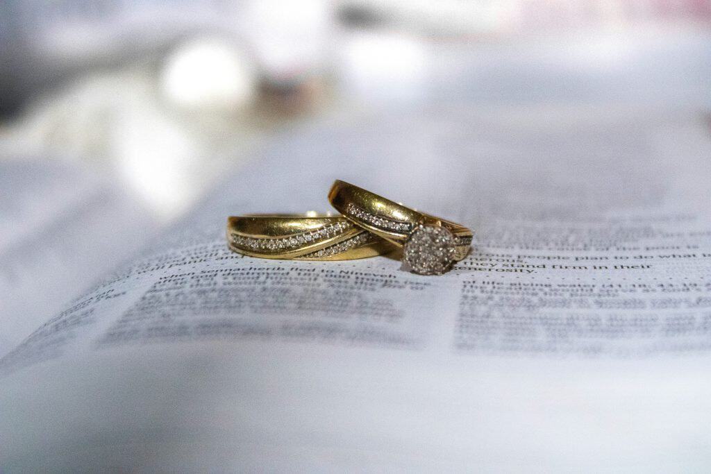 Wedding rings placed on legal document symbolizing divorce and family law services.