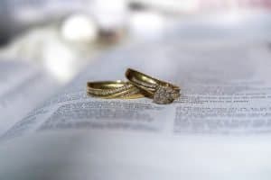 Wedding rings placed on legal document symbolizing divorce and family law services.