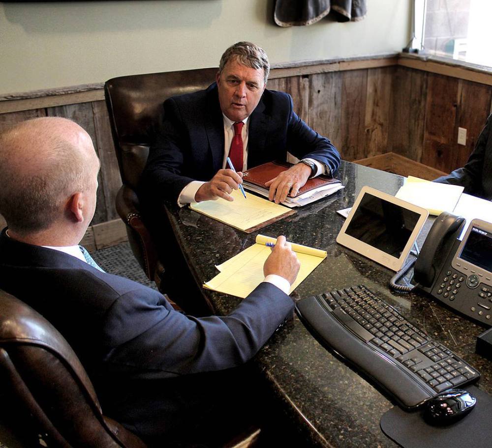 Attorney consulting with client in office, discussing legal case and strategies.