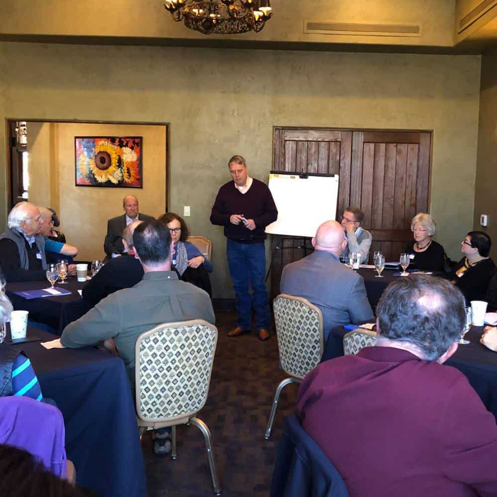 Attorney presenting legal seminar to a group of professionals in a conference room.