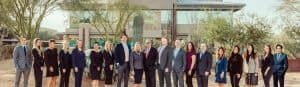 A diverse group of professionals standing outdoors in front of Dana Whiting Law office.