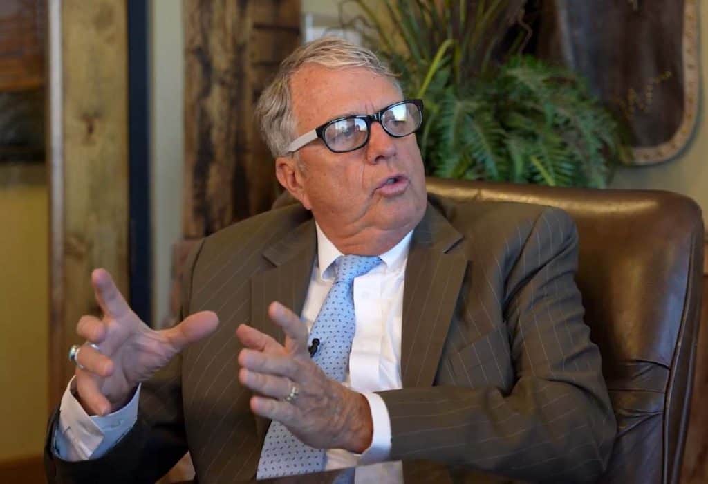 Matt Dana in a suit speaking passionately during an interview or discussion.