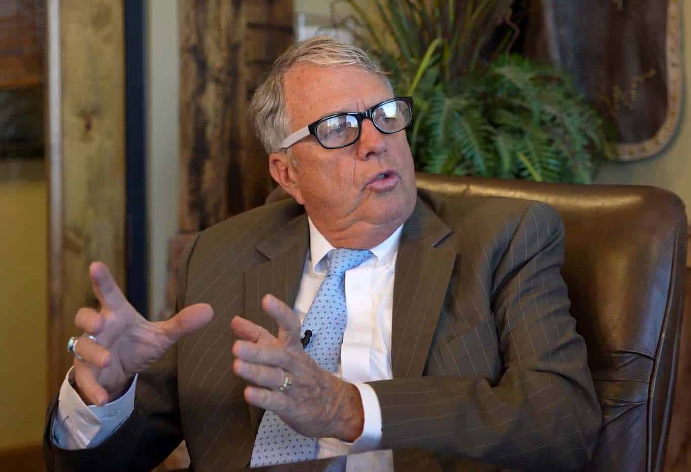 Matt Dana in a suit speaking passionately during an interview or discussion.