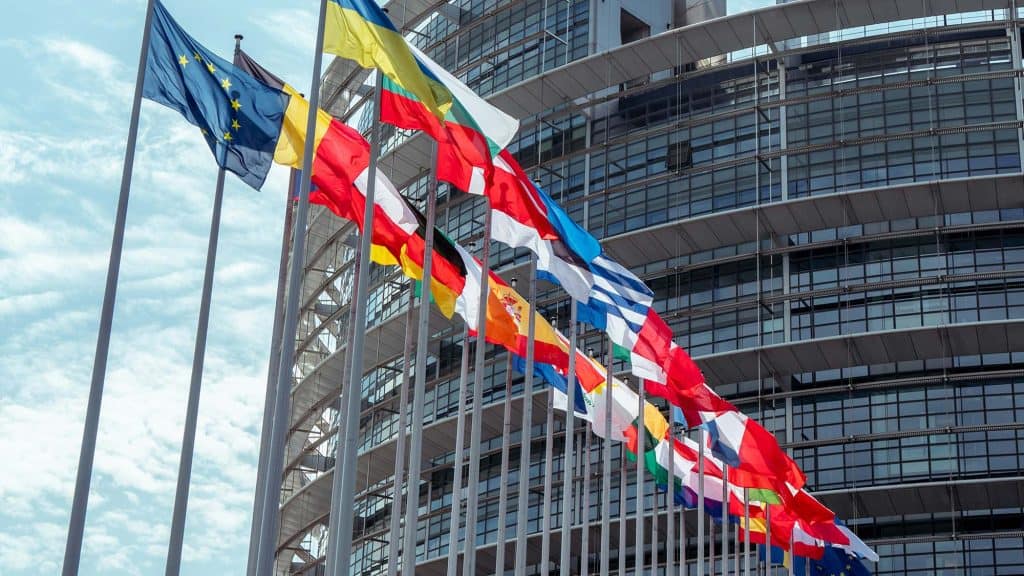 International flags flying outside a modern office building.