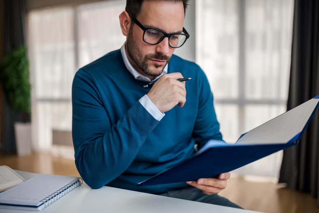 Business professional reviewing legal documents at desk in office.