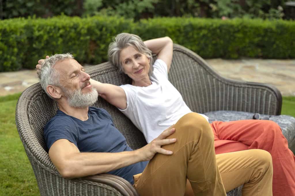 Elderly couple enjoying a peaceful moment on a garden bench.