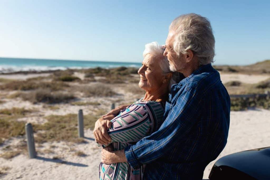 Relaxing elderly couple enjoying the beach scenery.