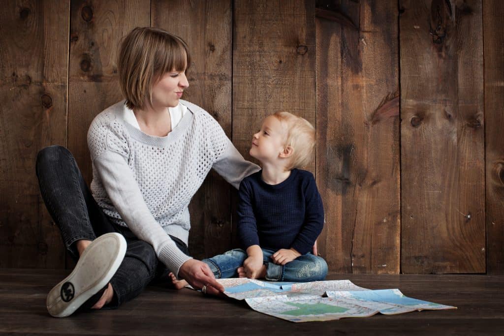 Woman and child reading maps indoors, family planning, or travel concept.