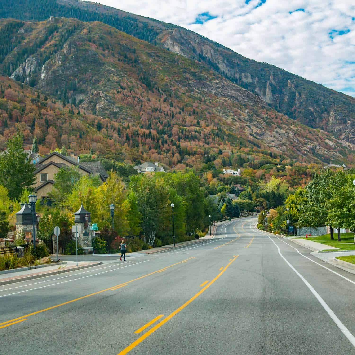 Mountain town street with colorful fall foliage and mountain backdrop.